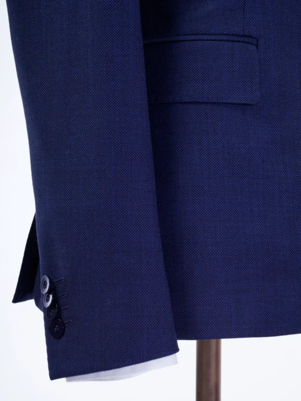 A close up of the sleeve and pocket on a suit.