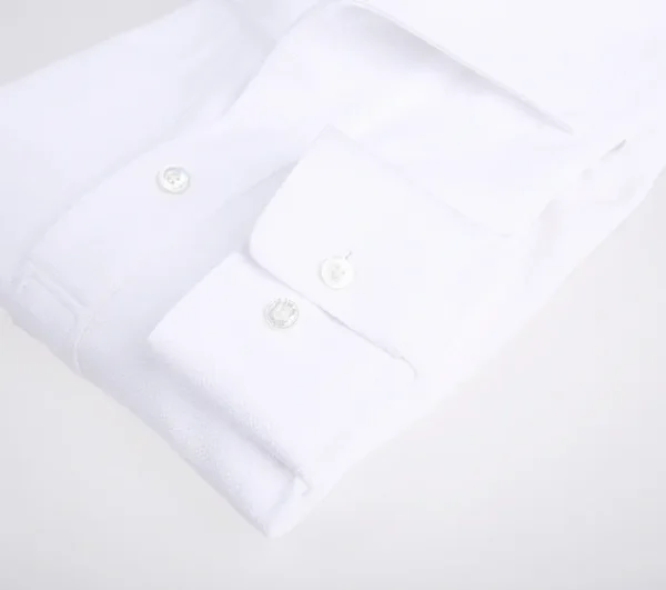 A close up of the buttons on a white shirt