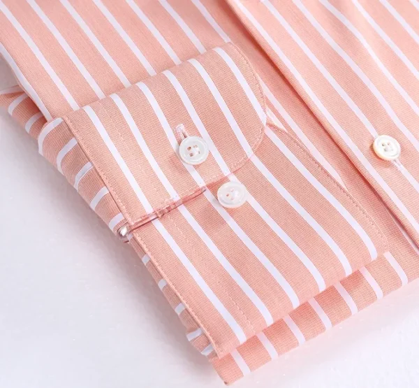 A close up of the buttons on a pink striped shirt