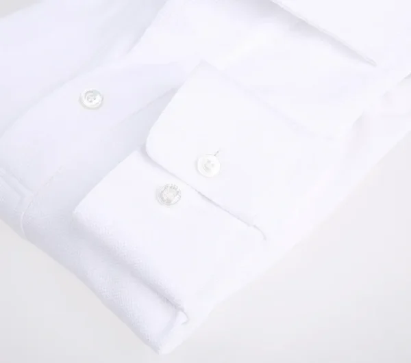 A close up of the buttons on a white shirt