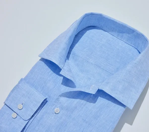 A blue shirt is folded and has no buttons.