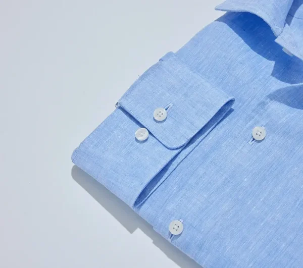 A blue shirt with white buttons and a pocket.