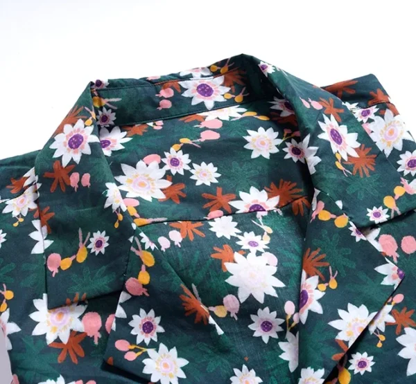 A green shirt with white and pink flowers on it.