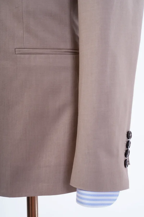 A close up of the sleeve and button on a suit jacket.