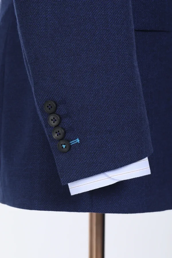 A close up of the sleeve and button on a suit jacket.