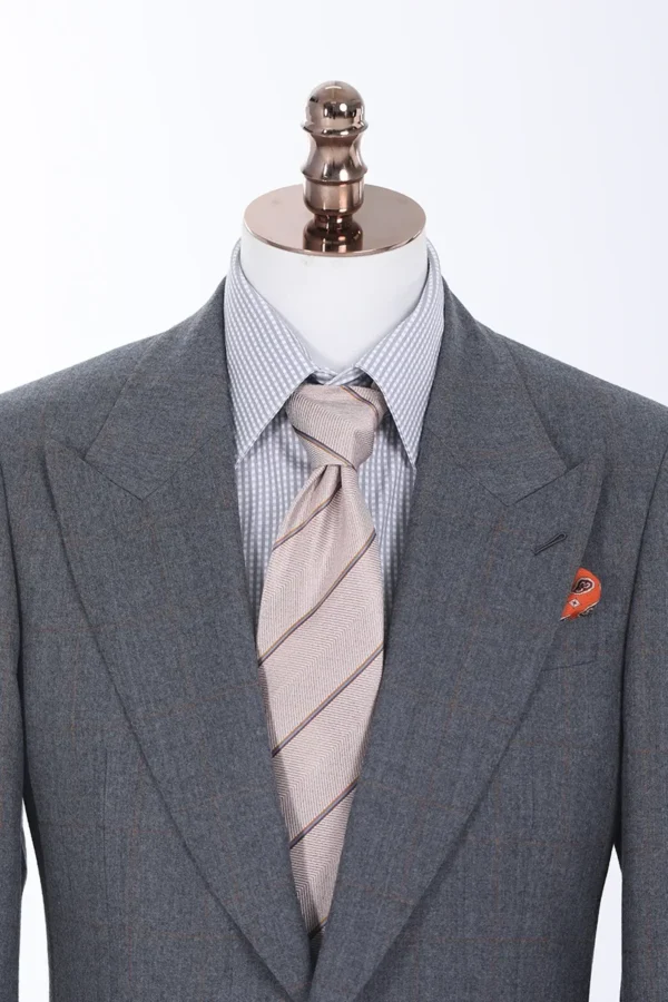 A suit and tie on display in front of a white background.