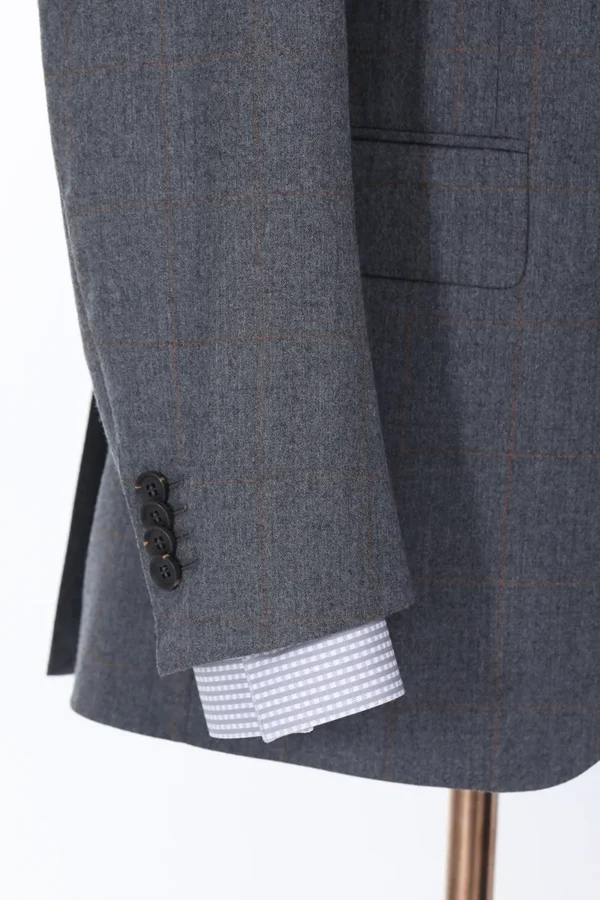 A close up of the sleeve and button on a suit