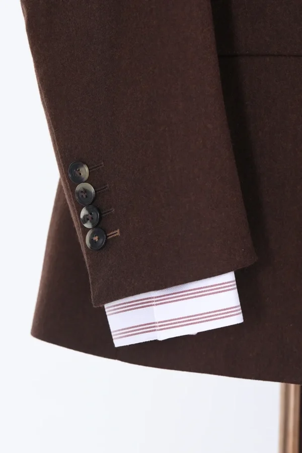 A close up of the sleeve and button on a suit jacket.