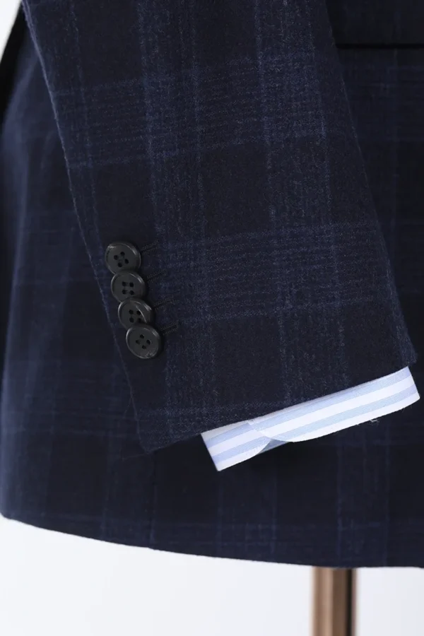 A close up of the sleeve and button on a suit.