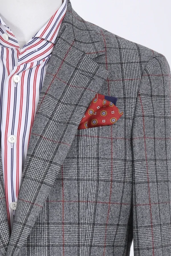 A man in a suit and tie with a polka dot pocket square.