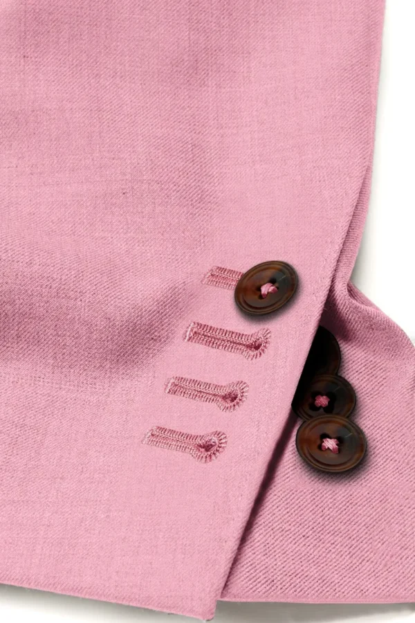 A close up of buttons on the sleeve of a pink jacket.