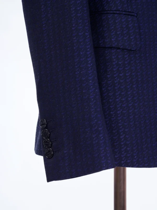 A close up of the sleeve and button on a suit.