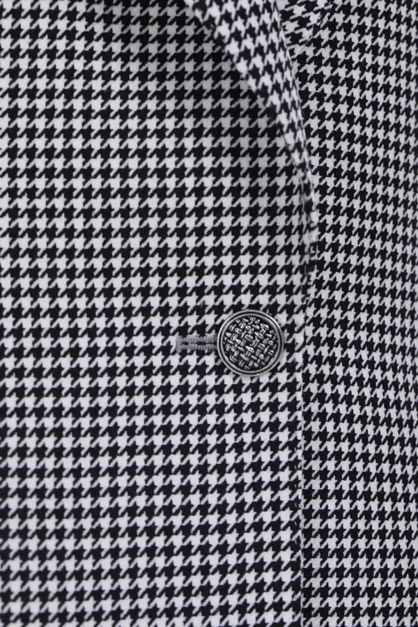 A close up of the button on a black and white jacket