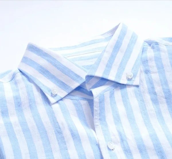 A close up of the collar and button on a shirt