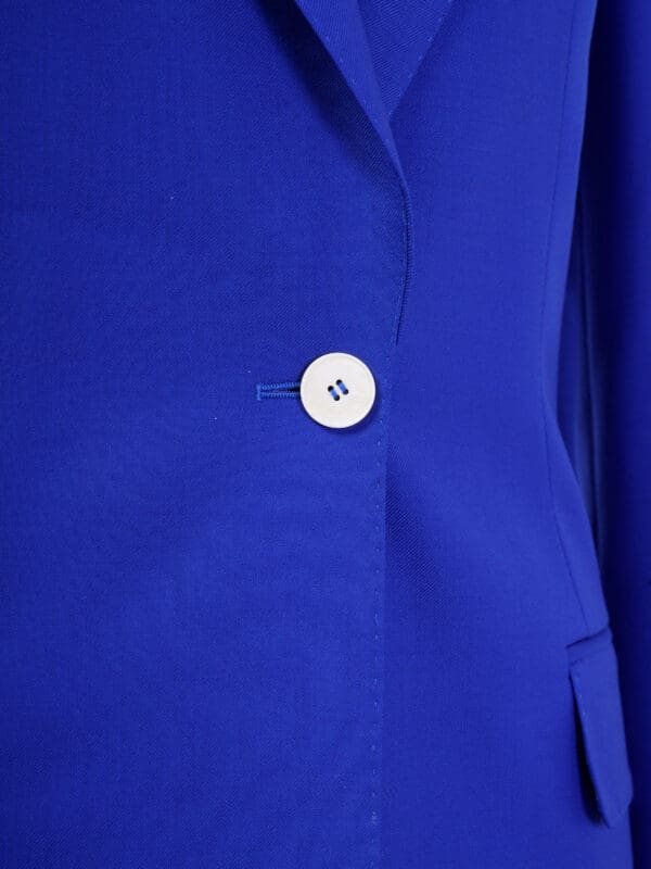 A close up of the button on a blue jacket