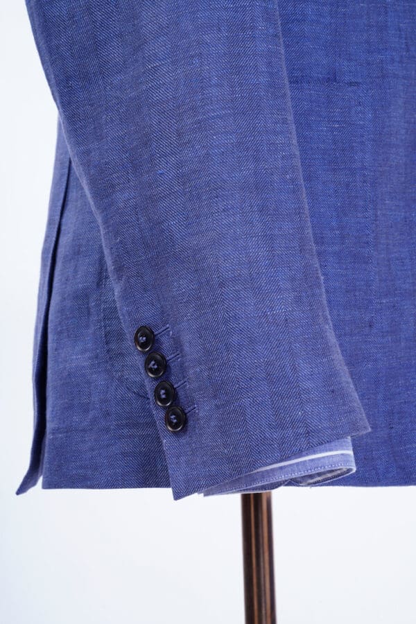 A close up of the sleeve and button on a suit jacket.