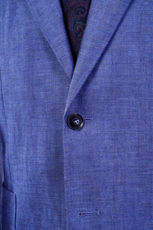 A close up of the button on a blue jacket