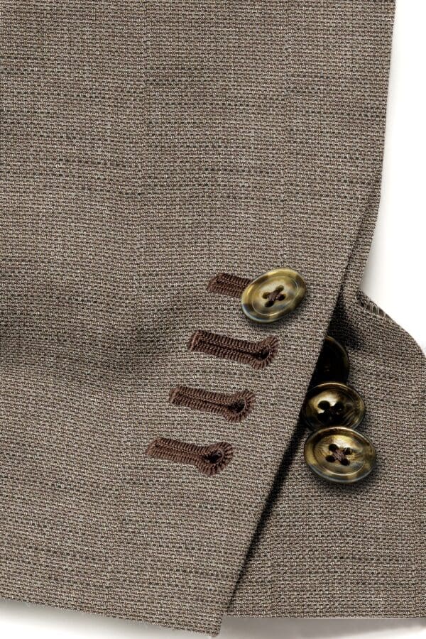 A close up of buttons on the side of a suit jacket.