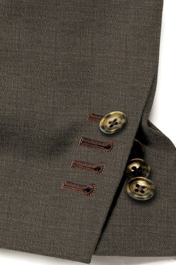 A close up of buttons on the side of a suit jacket.